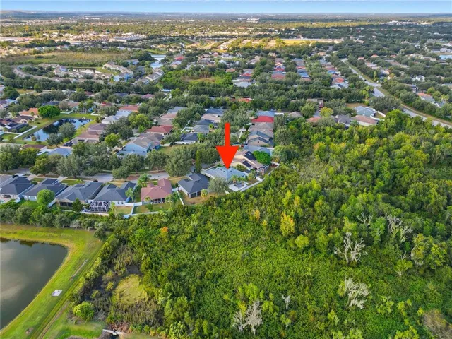 an aerial view of residential houses with outdoor space and trees