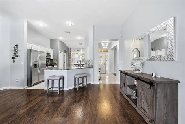 a kitchen with stainless steel appliances kitchen island wooden floors and white cabinets