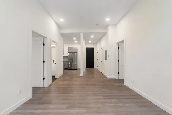 a view of a hallway with wooden floor