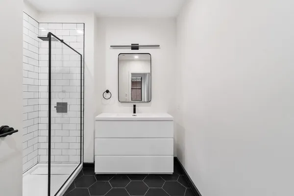 a bathroom with a sink a toilet and shower