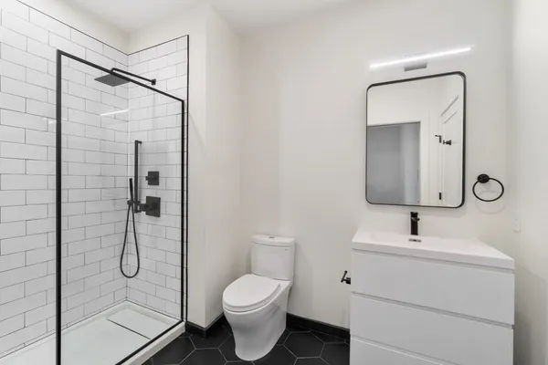 a bathroom with a granite countertop sink toilet and shower
