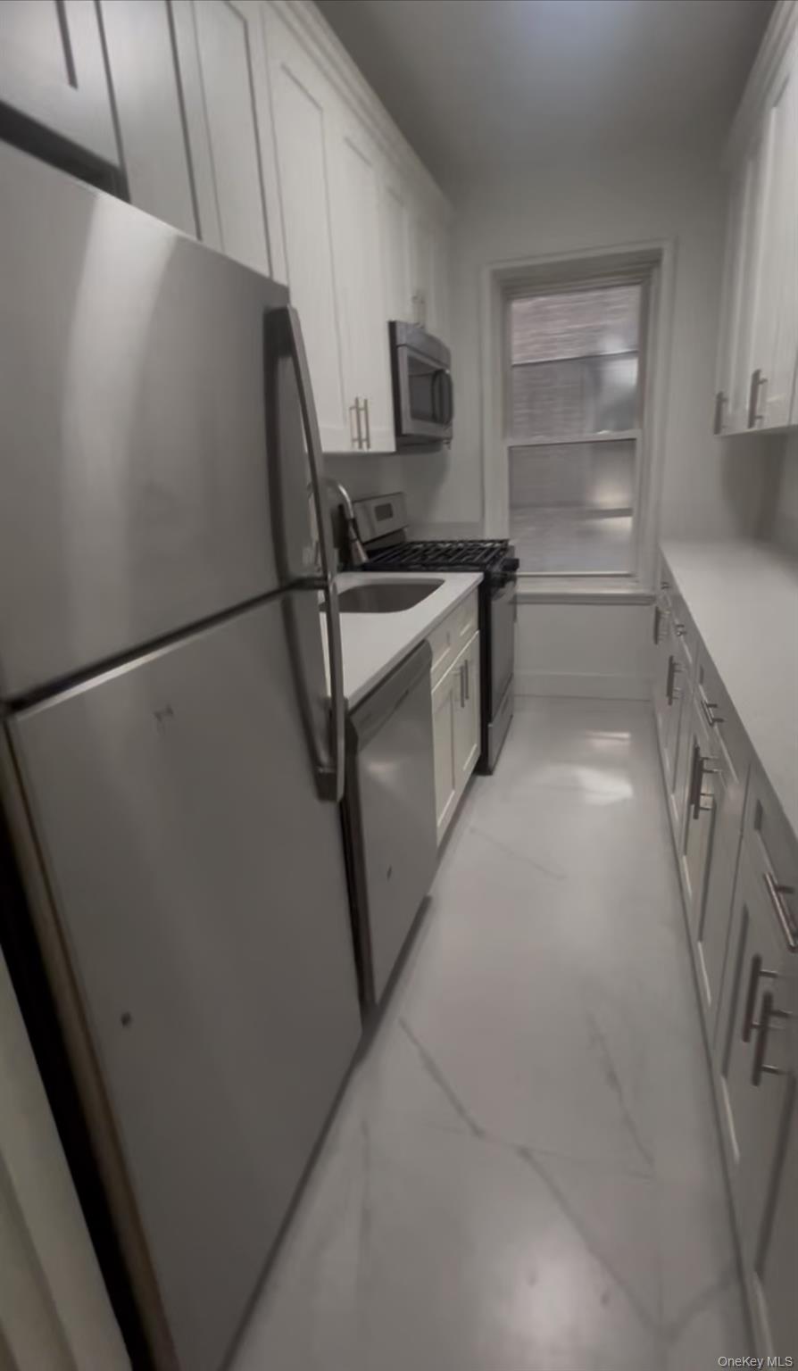 3810 Greystone Avenue, Unit 106 Bronx, NY 10463 - Photo 2 of 8 a kitchen with a refrigerator and a stove