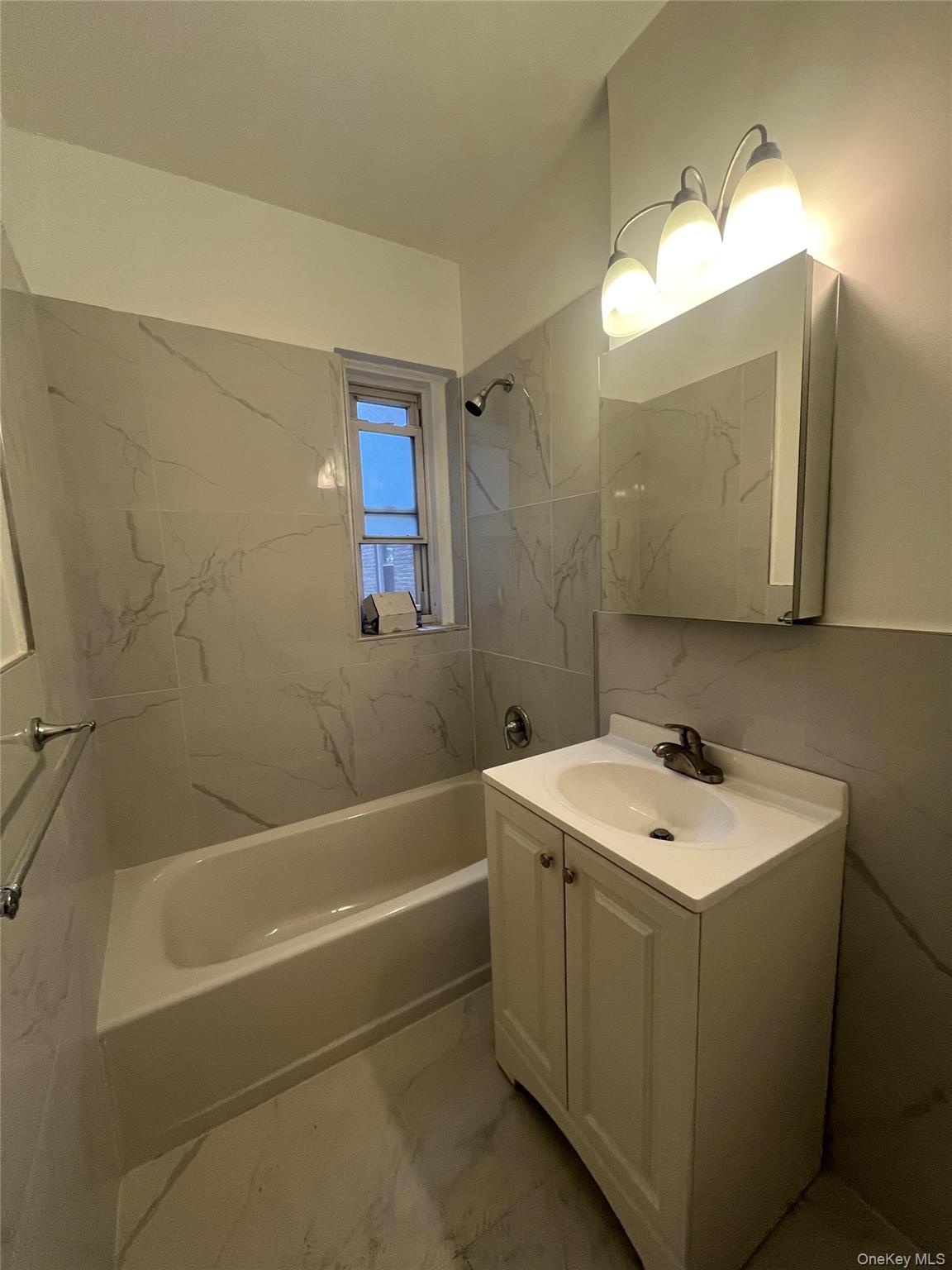 3810 Greystone Avenue, Unit 106 Bronx, NY 10463 - Photo 4 of 8 a bathroom with a sink a toilet and a mirror