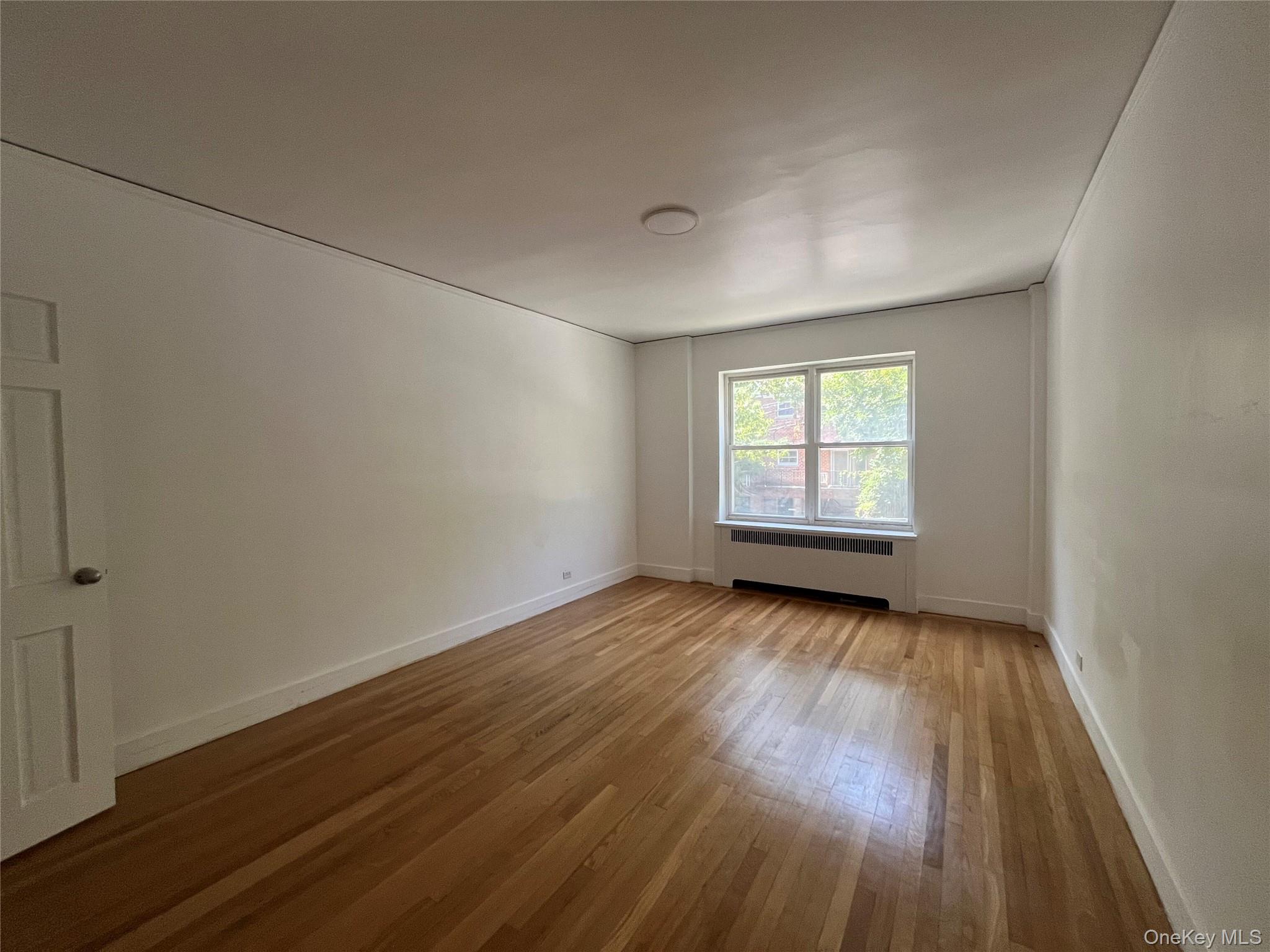 3810 Greystone Avenue, Unit 106 Bronx, NY 10463 - Photo 7 of 8 an empty room with wooden floor and windows