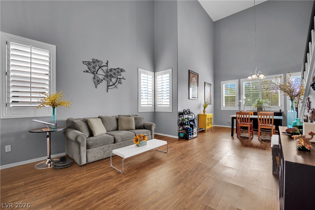 1724 Millstream Way Henderson, NV 89074 - Photo 8 of 60 Lofty vaulted ceilings elevate this open-concept living space with rich hardwood flooring and abundant natural light.
