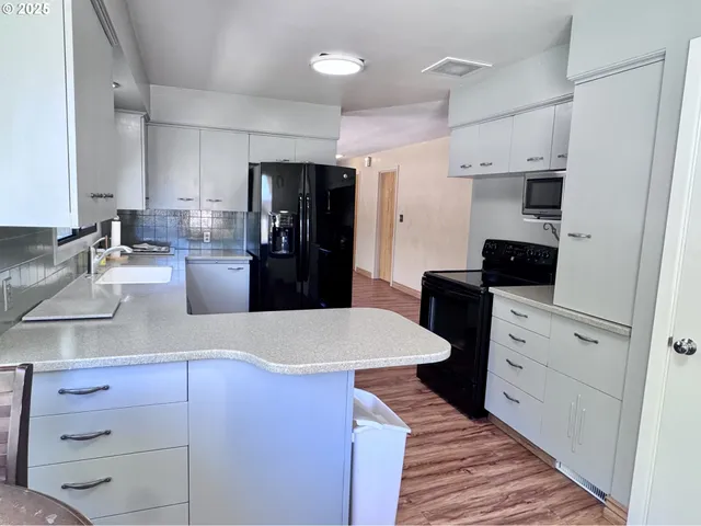 a kitchen with a refrigerator and a stove top oven