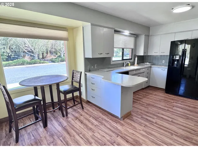 a kitchen with a table chairs refrigerator and cabinets