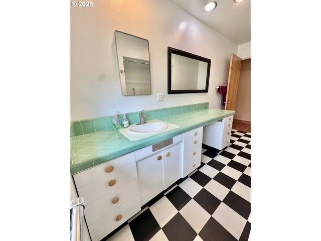 a bathroom with a granite countertop sink and mirror