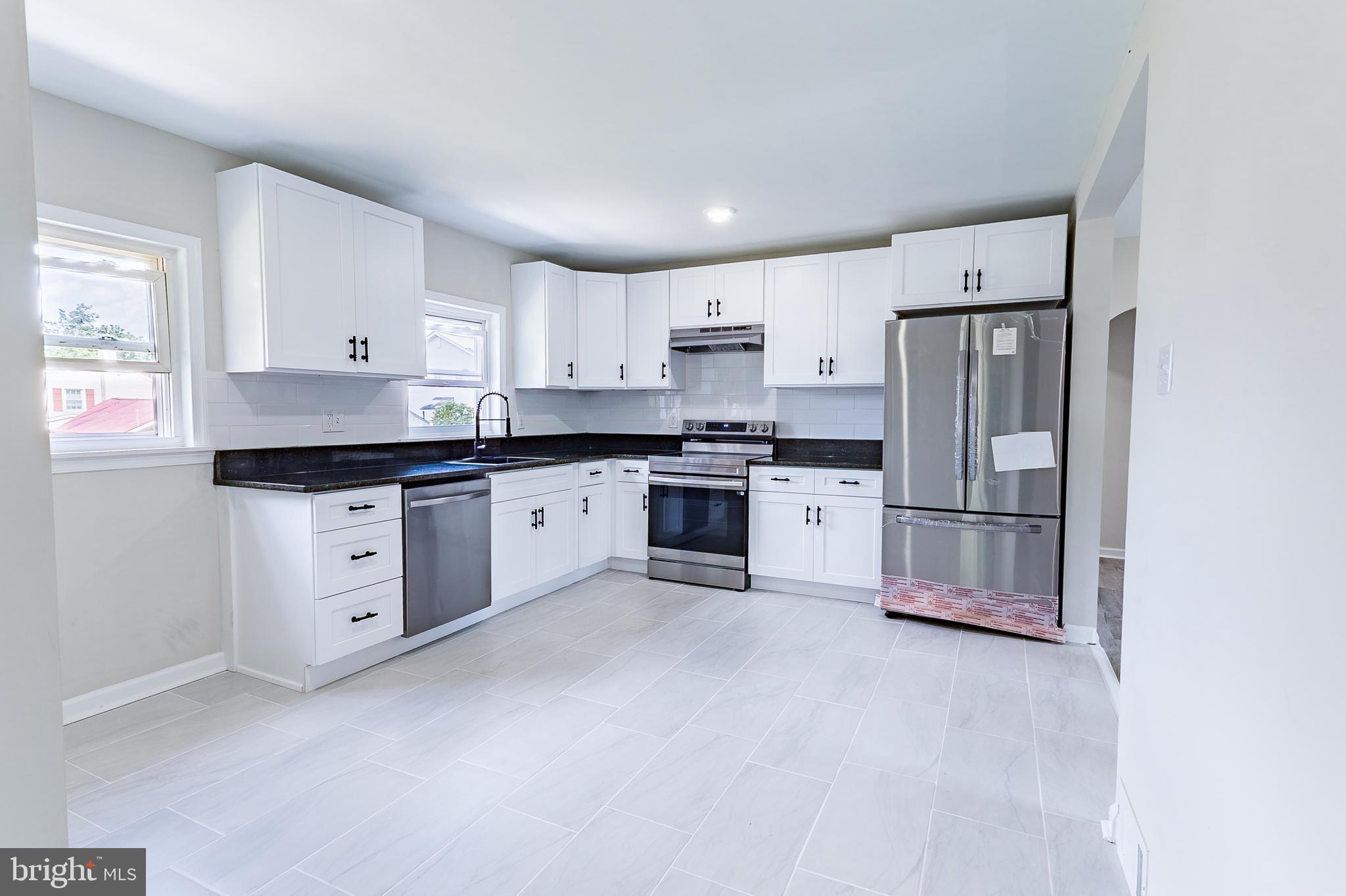 a kitchen with white cabinets stainless steel appliances and a window