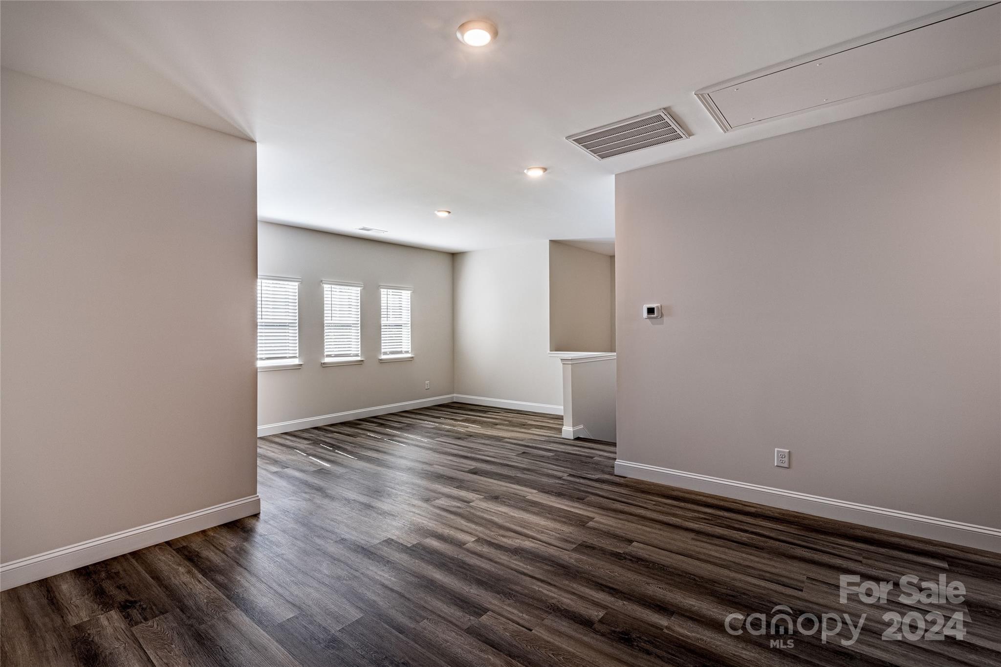 9531 Pointer Road, Unit 74 Huntersville, NC 28078 - Photo 9 of 16 a view of an empty room with wooden floor and a window