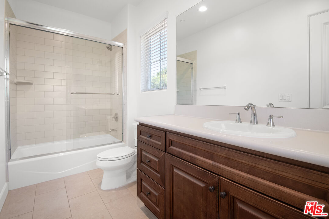 18326 Columbus Circle Tarzana, CA 91356 - Photo 27 of 34 a bathroom with a sink a toilet a mirror and shower