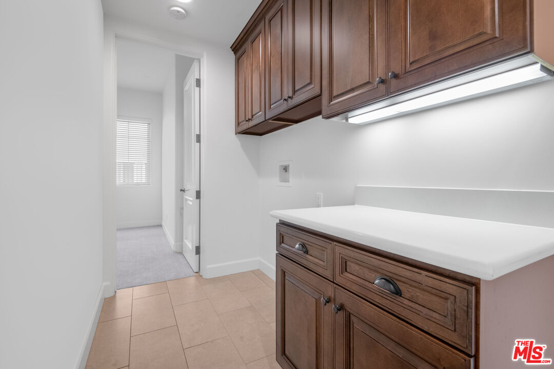 18326 Columbus Circle Tarzana, CA 91356 - Photo 31 of 34 a kitchen with granite countertop cabinets and utility