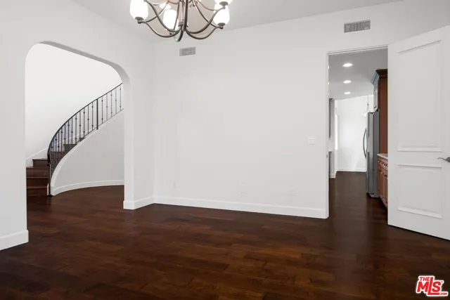 an empty room with wooden floor fireplace and windows