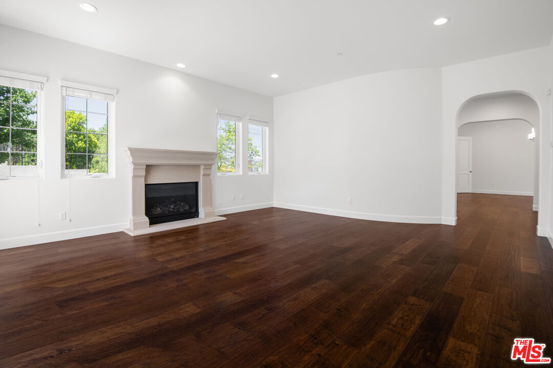 18326 Columbus Circle Tarzana, CA 91356 - Photo 7 of 34 an empty room with wooden floor fireplace and windows