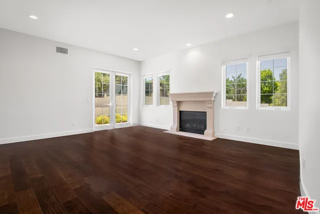 a view of a livingroom with a chandelier fan and wooden floor