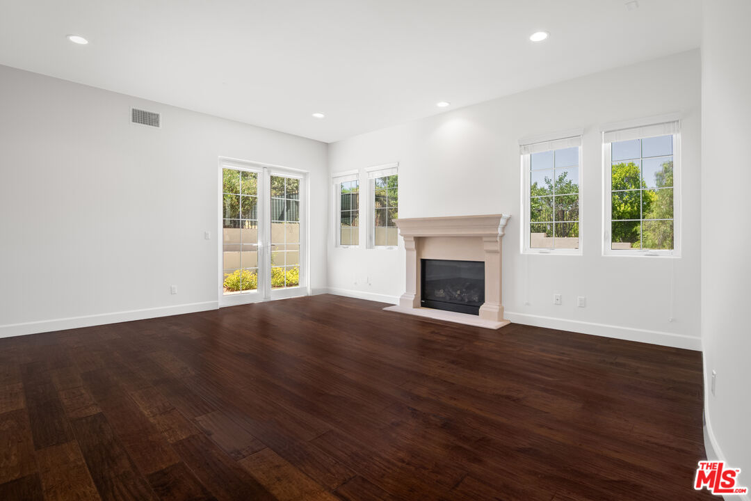 18326 Columbus Circle Tarzana, CA 91356 - Photo 8 of 34 an empty room with wooden floor and a fireplace