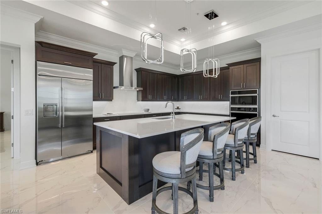 2488 Breakwater Way, Unit 201 Naples, FL 34112 - Photo 11 of 48 a kitchen with a table and chairs in it