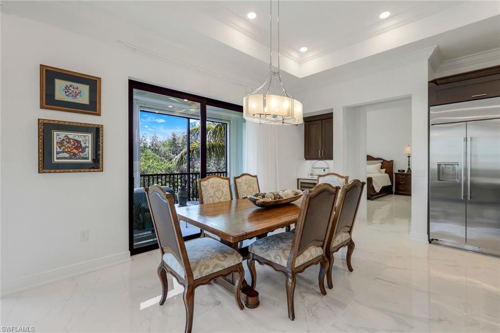 2488 Breakwater Way, Unit 201 Naples, FL 34112 - Photo 12 of 48 a view of a dining room with furniture and a chandelier