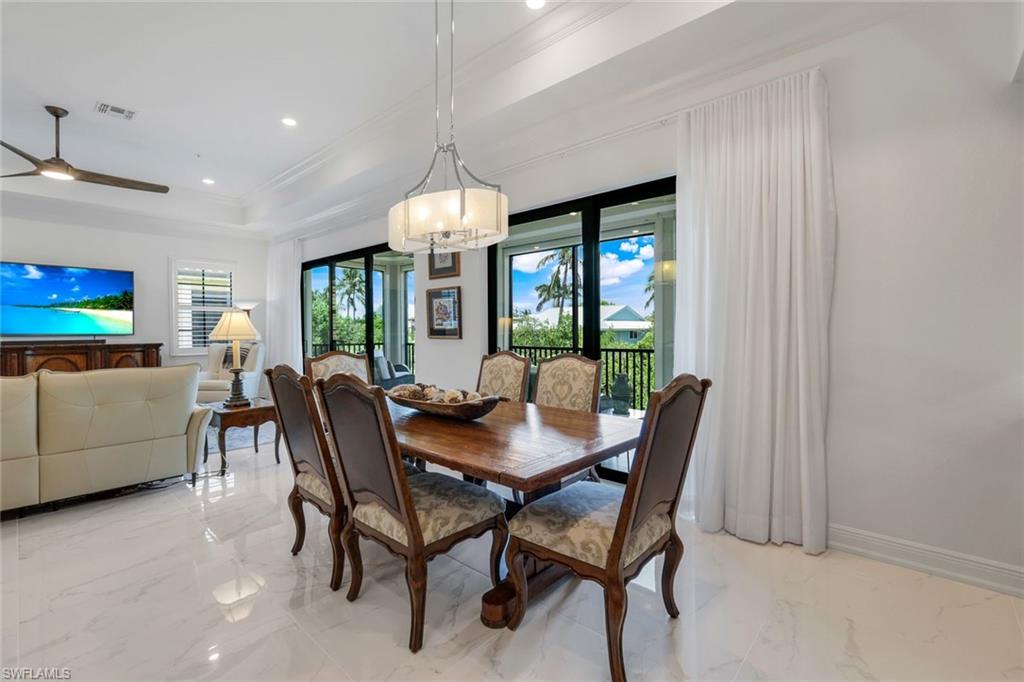 2488 Breakwater Way, Unit 201 Naples, FL 34112 - Photo 13 of 48 a view of a dining room with furniture and a chandelier
