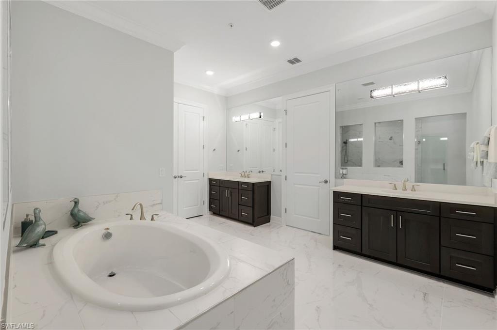 2488 Breakwater Way, Unit 201 Naples, FL 34112 - Photo 17 of 48 a spacious bathroom with a double vanity sink and a bathtub