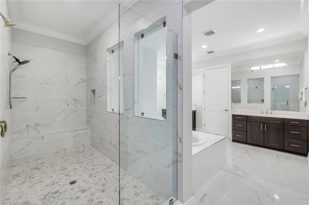 2488 Breakwater Way, Unit 201 Naples, FL 34112 - Photo 18 of 48 a bathroom with a tub shower vanity and a sink