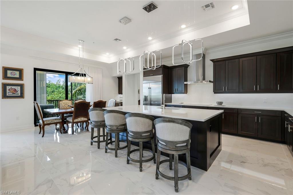 2488 Breakwater Way, Unit 201 Naples, FL 34112 - Photo 2 of 48 a kitchen with lots of counter top space and dining table