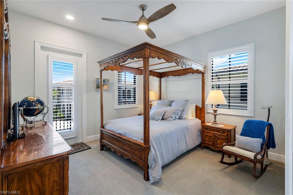 2488 Breakwater Way, Unit 201 Naples, FL 34112 - Photo 21 of 48 a bedroom with a bed and a chandelier