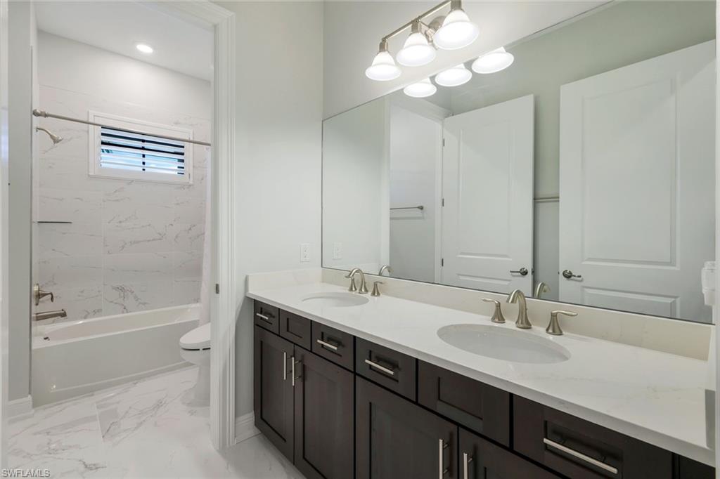2488 Breakwater Way, Unit 201 Naples, FL 34112 - Photo 22 of 48 a bathroom with a tub a sink and mirror
