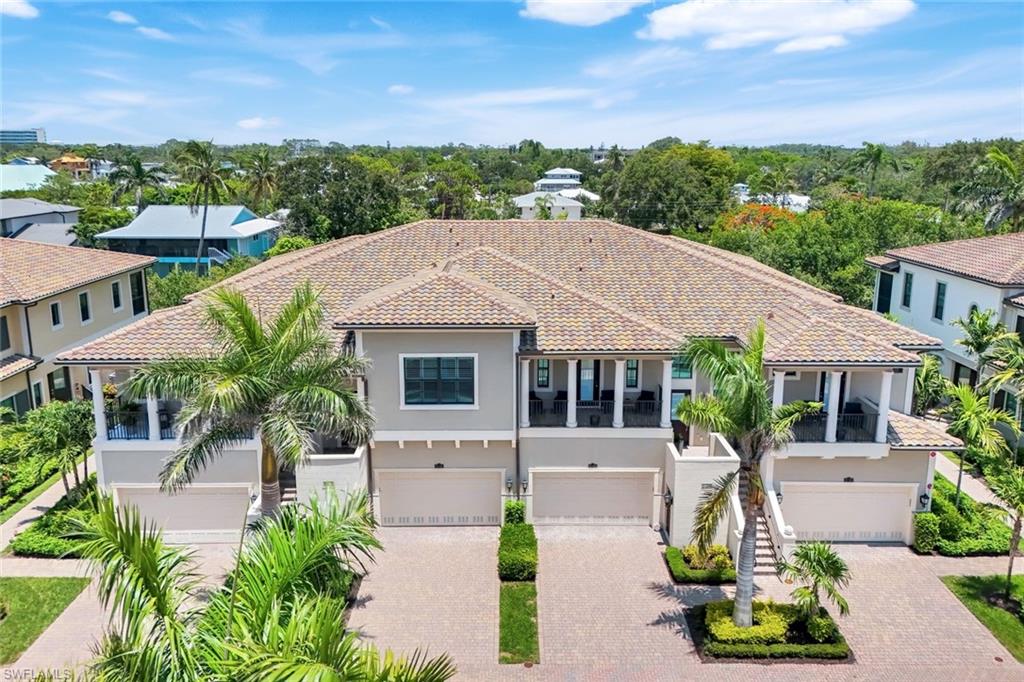 2488 Breakwater Way, Unit 201 Naples, FL 34112 - Photo 29 of 48 a front view of a house with a yard and potted plants