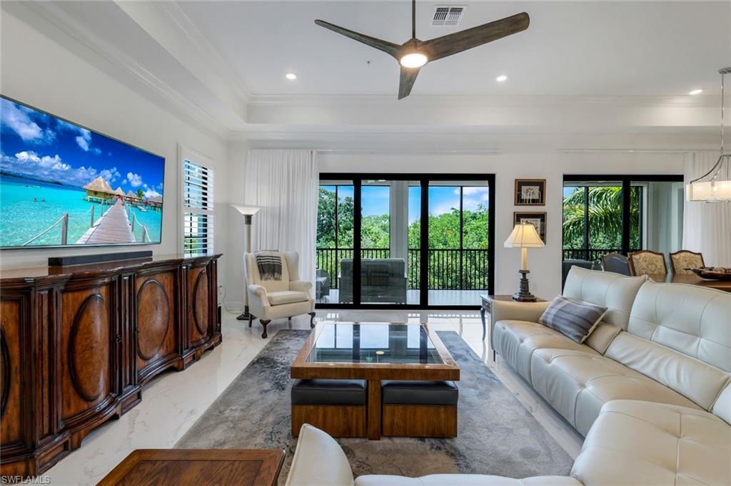 2488 Breakwater Way, Unit 201 Naples, FL 34112 - Photo 5 of 48 a living room with furniture flat screen tv and a large window