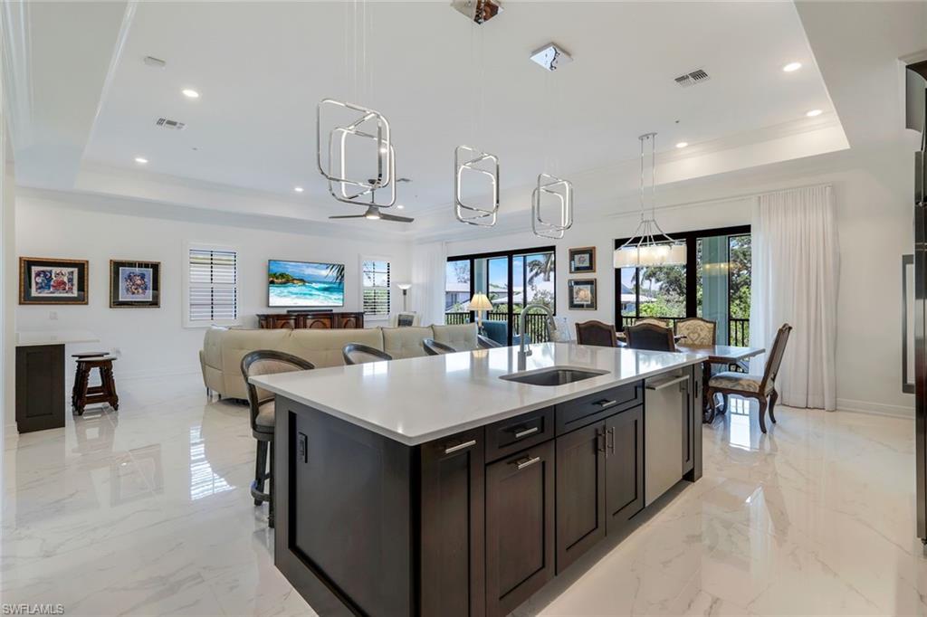 2488 Breakwater Way, Unit 201 Naples, FL 34112 - Photo 7 of 48 a kitchen with a kitchen island a sink and a stove
