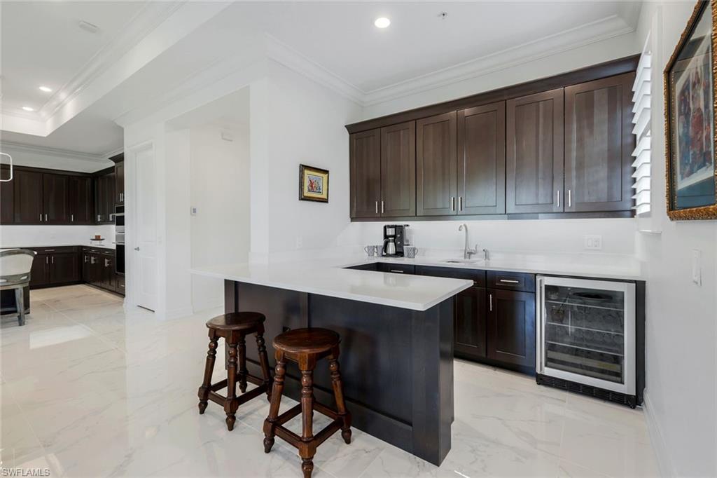 2488 Breakwater Way, Unit 201 Naples, FL 34112 - Photo 10 of 48 a kitchen with kitchen island a sink cabinets and appliances