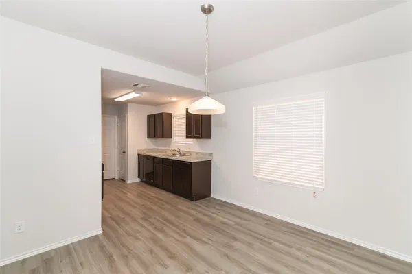 a kitchen with stainless steel appliances granite countertop a sink and a wooden floor