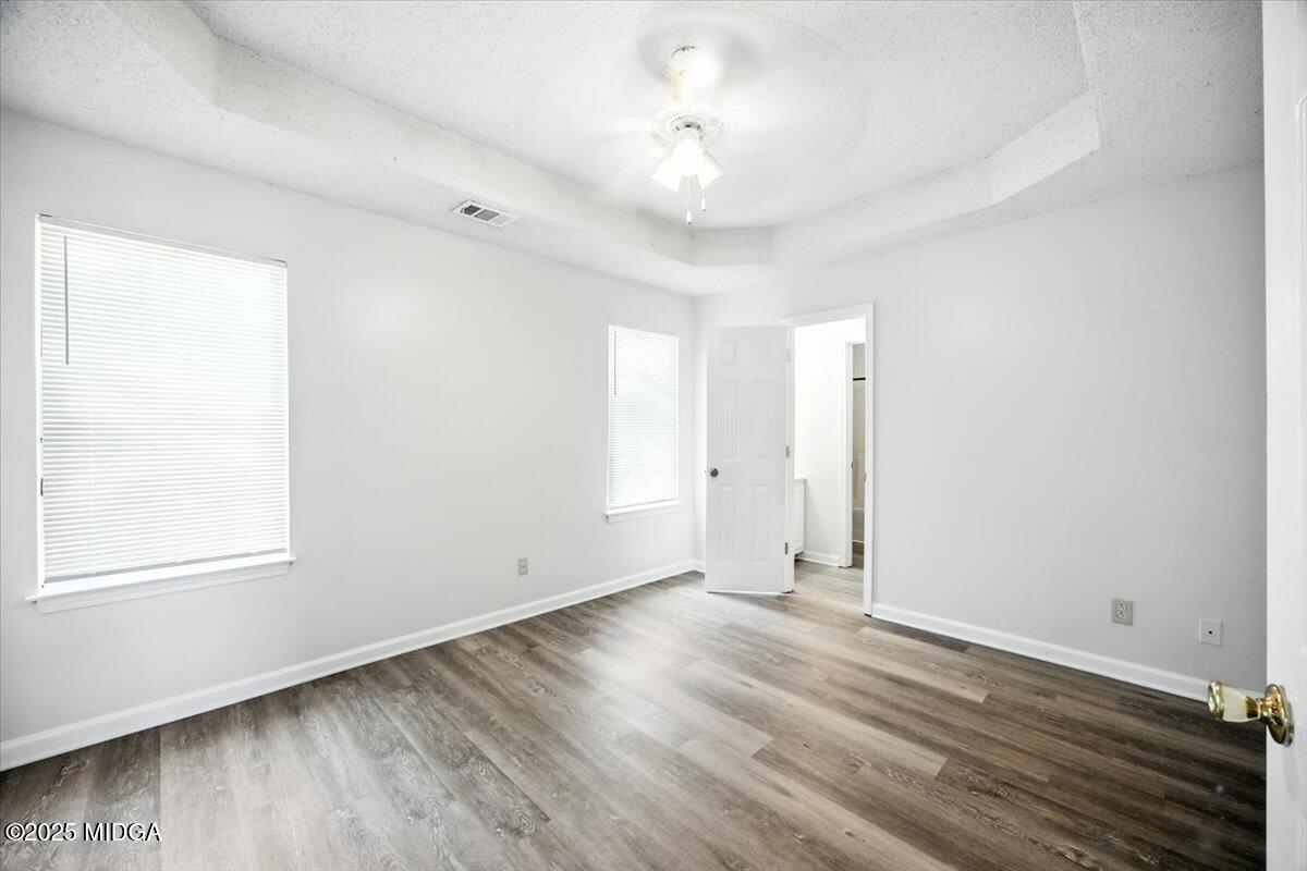 4801 Wilson Road Macon, GA 31206 - Photo 9 of 18 an empty room with wooden floor and windows