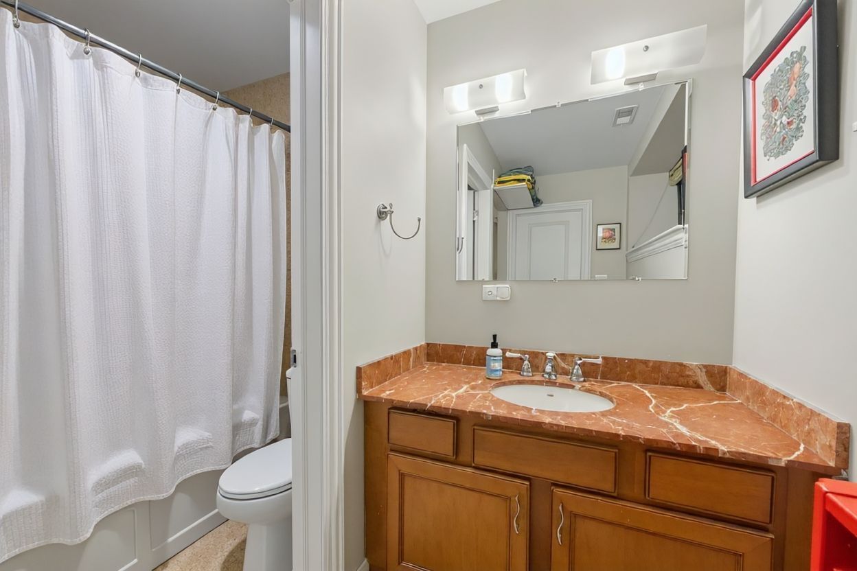 1647 West Addison Street, Unit 1B Chicago, IL 60613 - Photo 15 of 23 a bathroom with a granite countertop sink toilet and shower