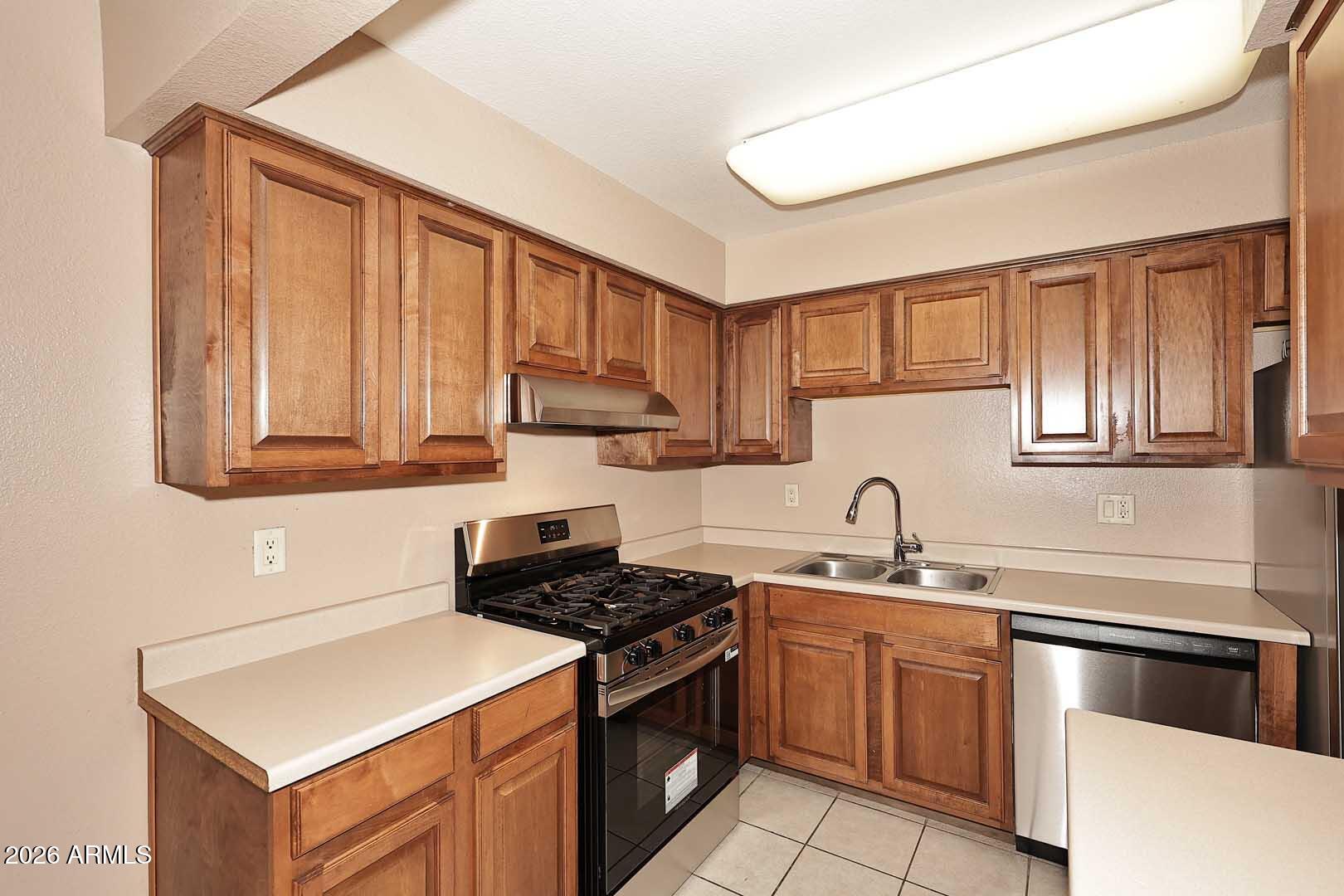 303 North Miller Road, Unit 1007 Scottsdale, AZ 85257 - Photo 15 of 45 a kitchen with a sink stove top oven and cabinets