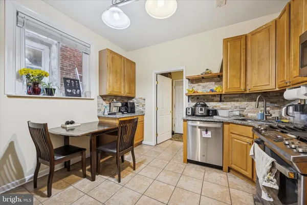 a kitchen with stainless steel appliances granite countertop a stove a sink dishwasher and cabinets with wooden floor