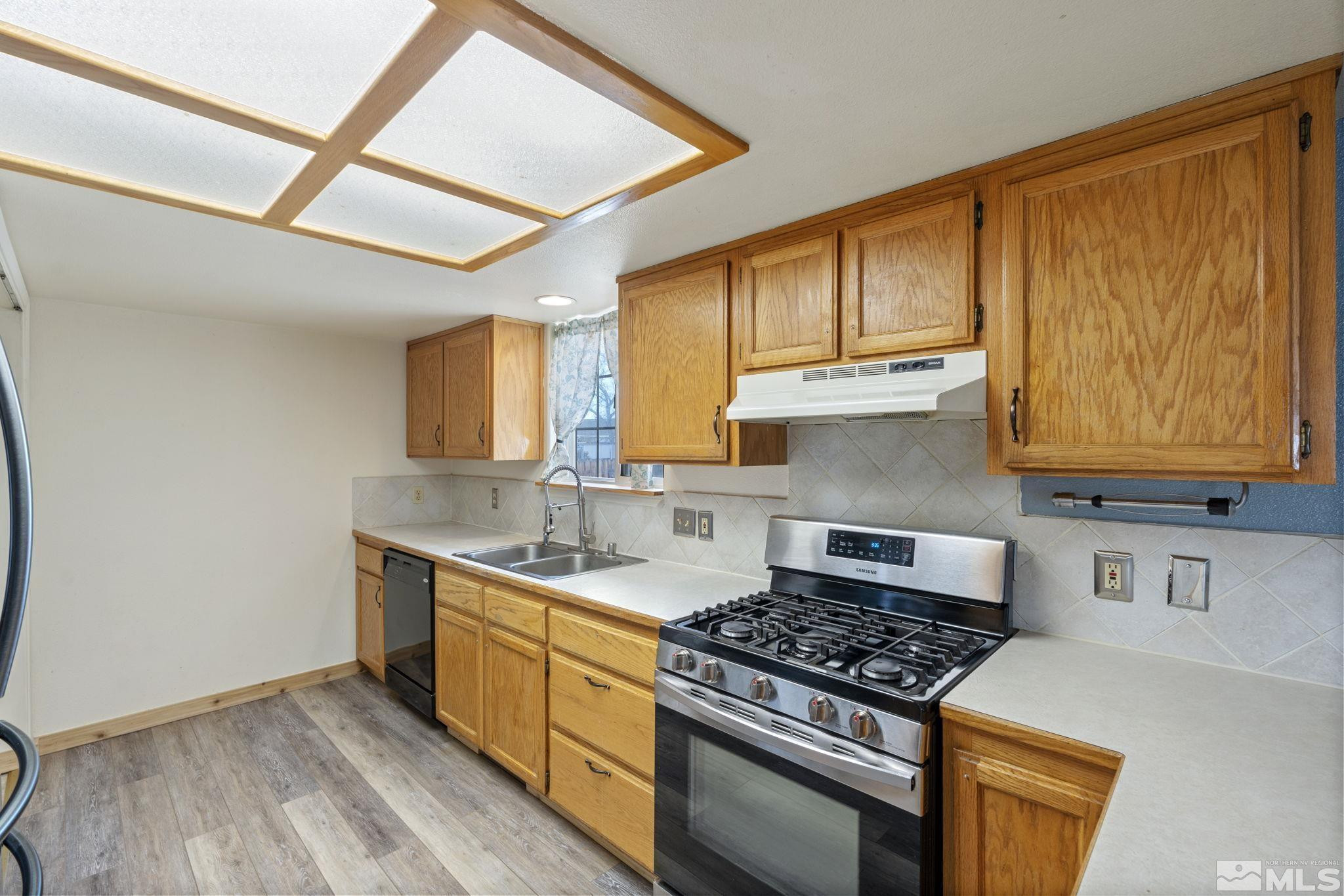 1240 Lattin Road Fallon, NV 89406 - Photo 16 of 34 a kitchen with stainless steel appliances granite countertop a stove a sink dishwasher and cabinets with wooden floor