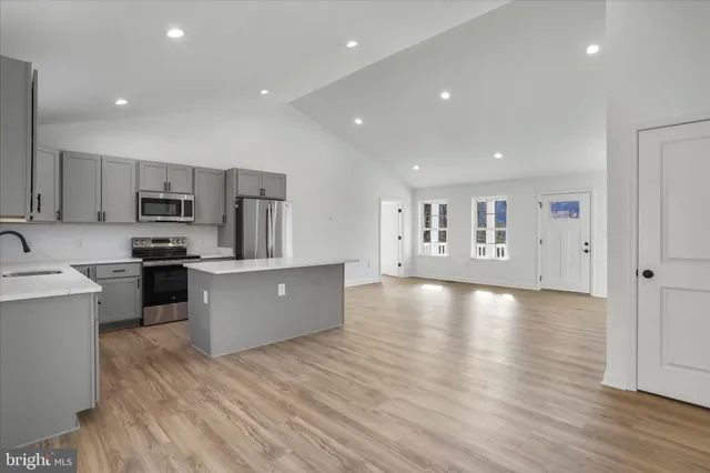 a kitchen with stainless steel appliances a refrigerator sink and white cabinets
