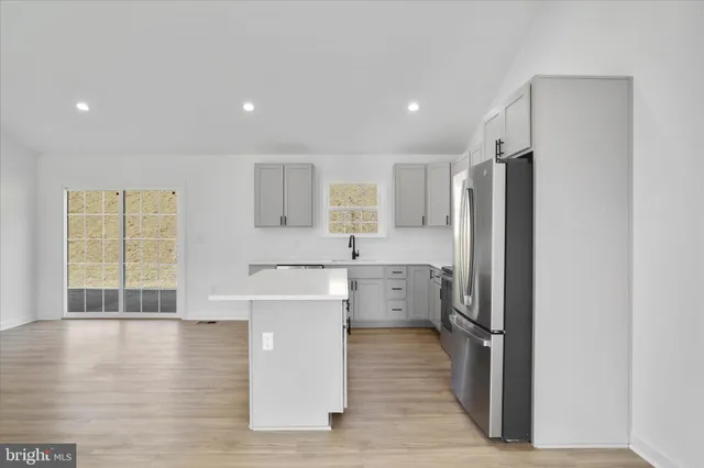 a kitchen with stainless steel appliances a refrigerator and a stove top oven