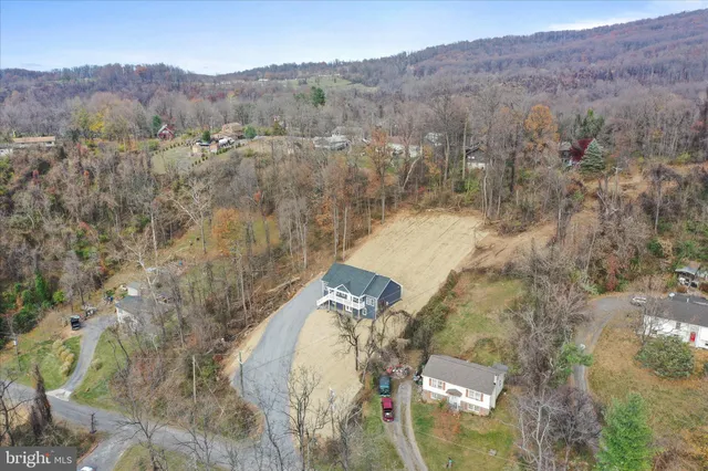 an aerial view of house with yard and mountain in the background