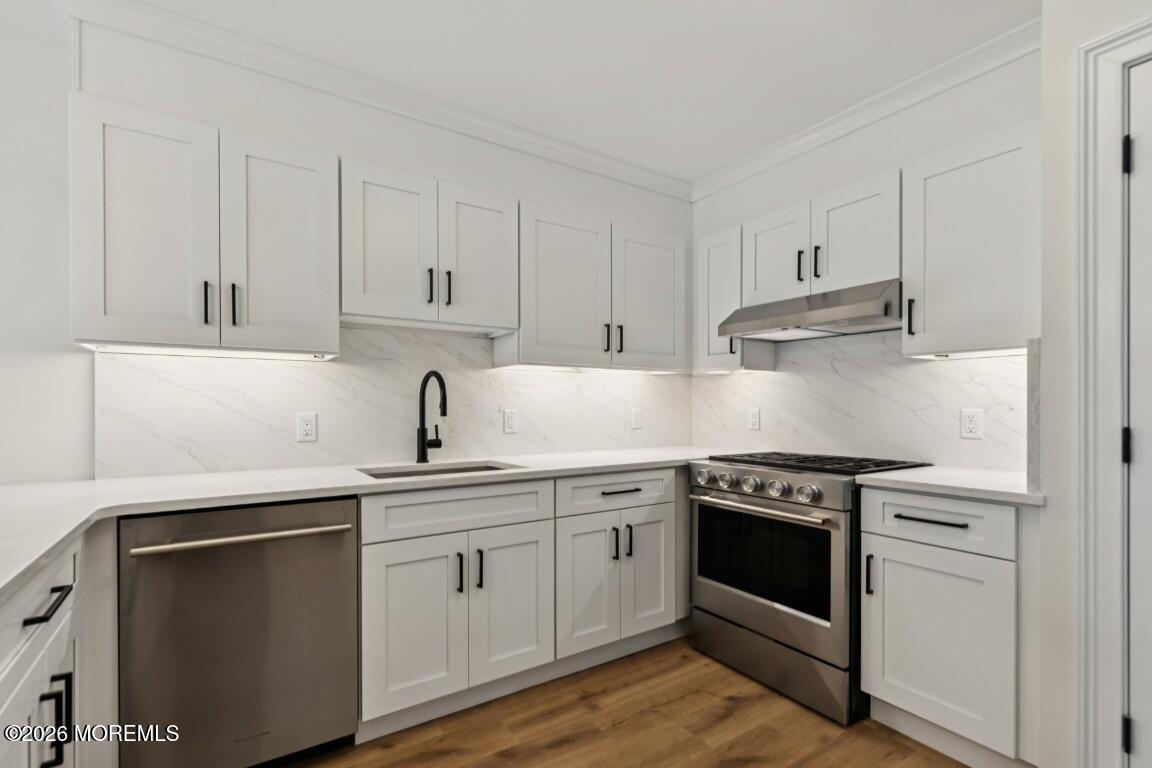 16 Shore Drive Long Branch, NJ 07740 - Photo 7 of 26 a kitchen with white cabinets and appliances