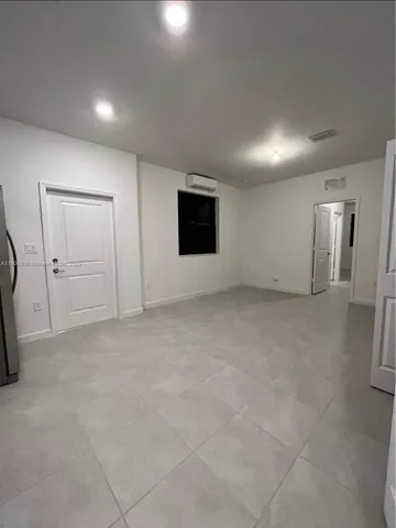 an empty room with staircase and mirror