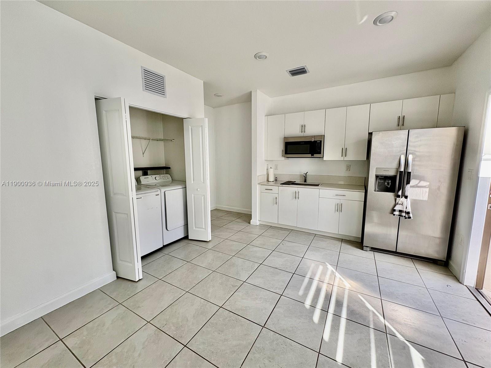 12950 Southwest 229th Lane, Unit 12950 Miami, FL 33170 - Photo 6 of 12 a kitchen with white cabinets and appliances