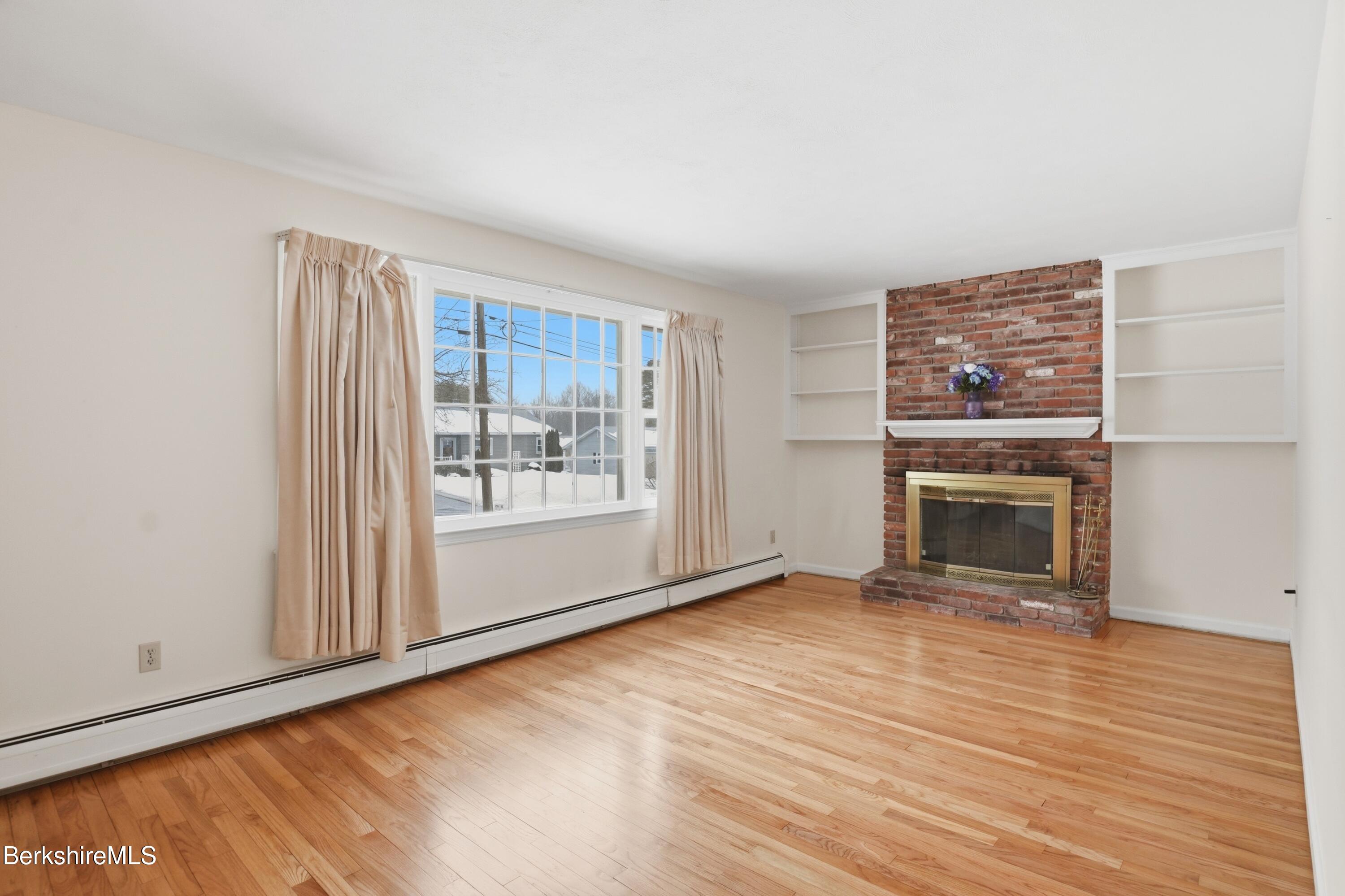 82 Quirico Drive Pittsfield, MA 01201 - Photo 14 of 30 wooden floor fireplace and windows in an empty room