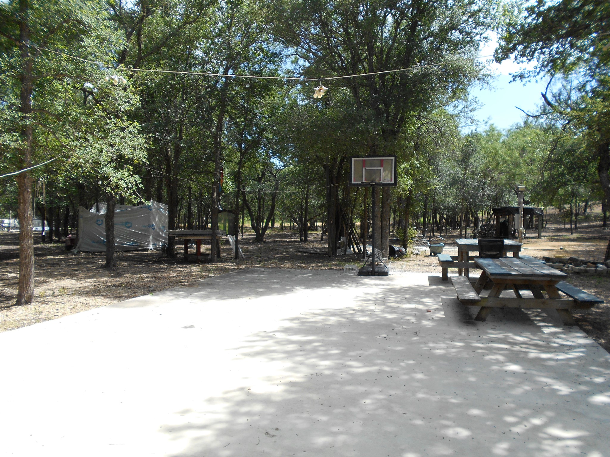 8001 Burleson Manor Road Manor, TX 78653 - Photo 26 of 31 Enjoy outdoor leisure with a picnic area and basketball hoop amid a grove of mature trees.