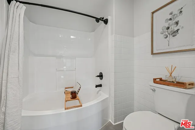 a white bath tub sitting next to a white toilet