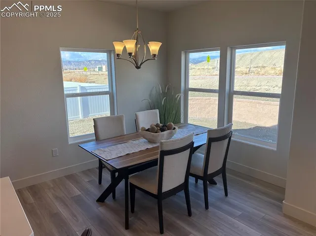 a view of a dining room with furniture a chandelier and wooden floor