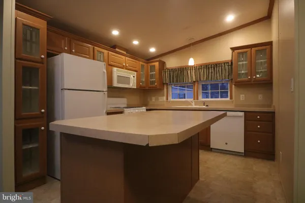a kitchen with kitchen island a sink a counter top and refrigerator