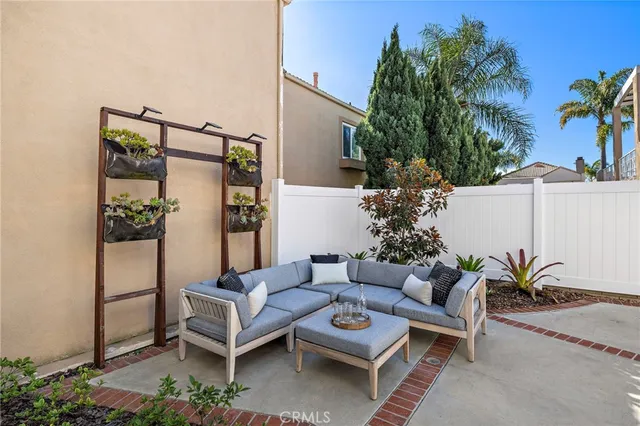a view of a patio with couches table and chairs and potted plants